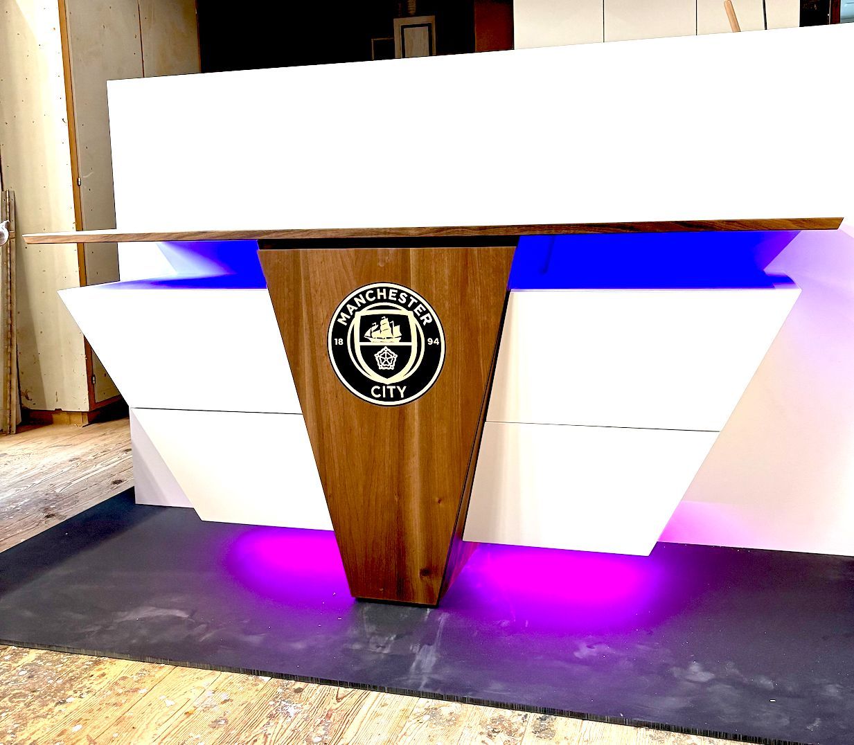 Ein Holztisch mit einem Logo darauf, auf dem Manchester City steht