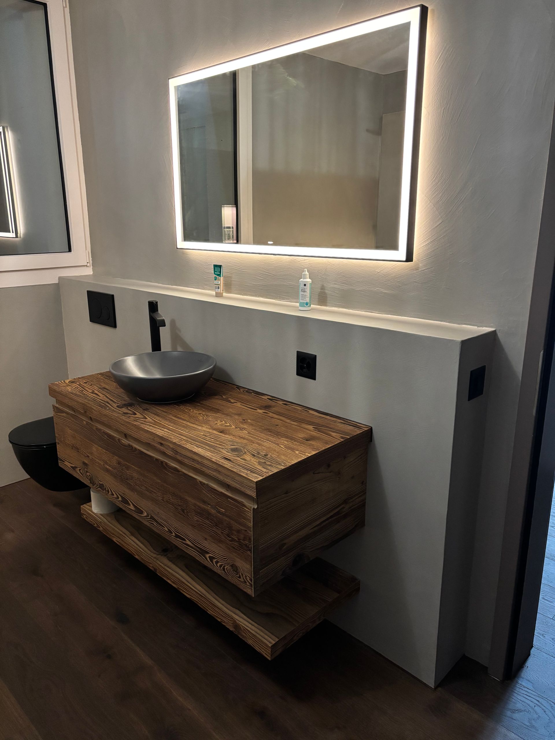 Ein Badezimmer mit Waschbecken, Spiegel und Toilette