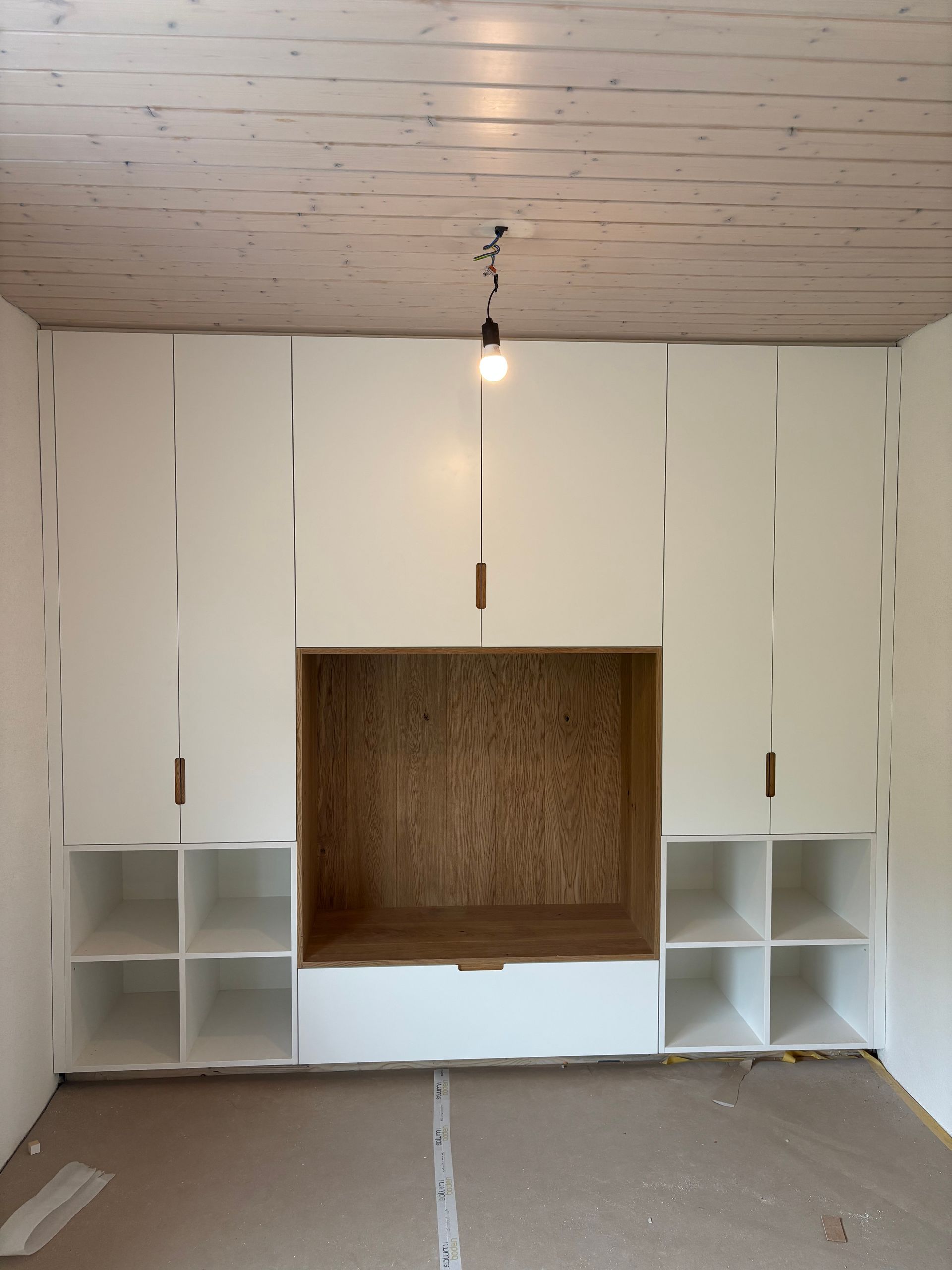 Ein leerer Raum mit weissen Schränken und Regalen