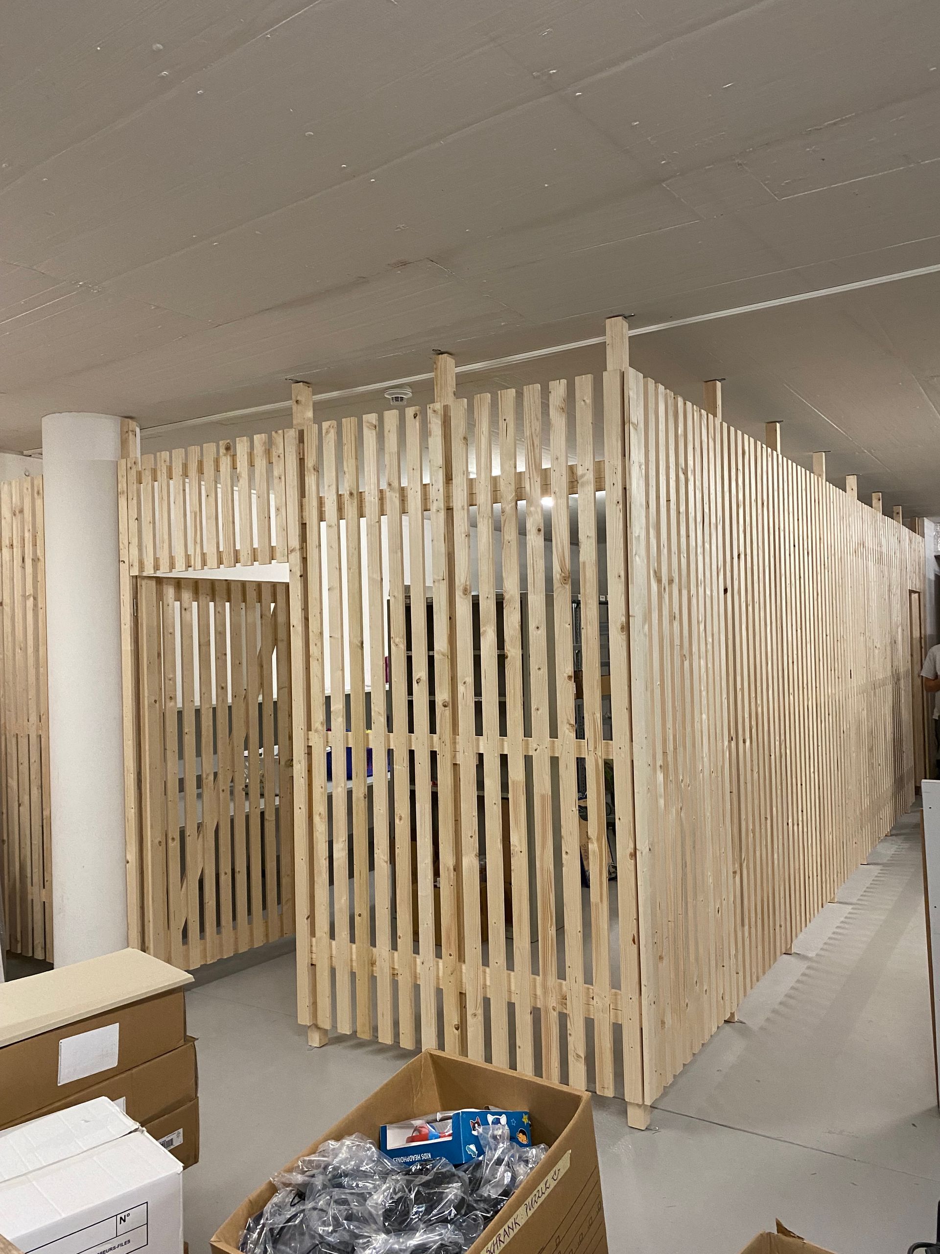 Ein Raum mit einem Holzzaun und Kisten auf dem Boden