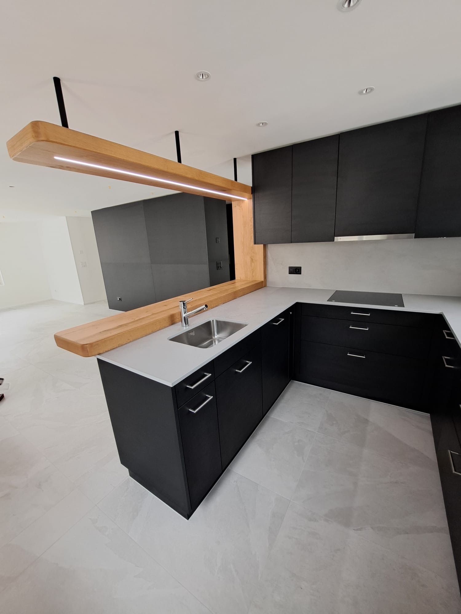 Eine Küche mit schwarzen Schränken und einer Spüle