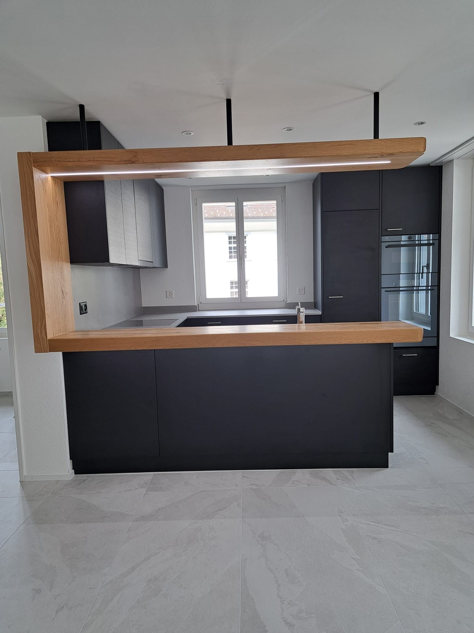 Eine Küche mit schwarzen Schränken und einer Holzarbeitsplatte