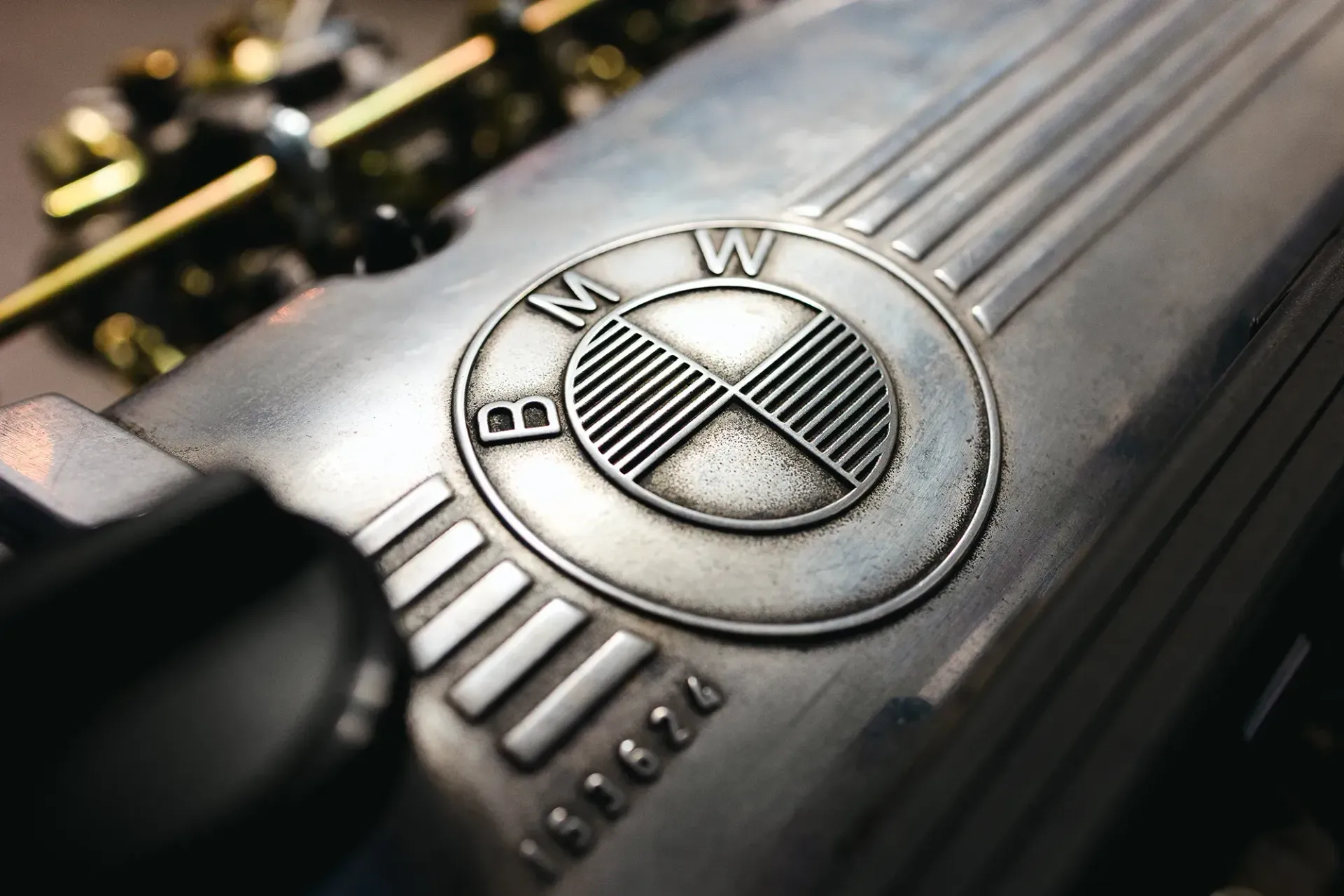 Eine Nahaufnahme eines BMW-Logos auf der Motorabdeckung eines Autos.