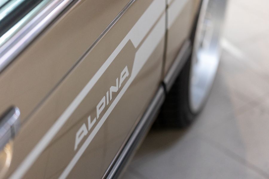 Eine Nahaufnahme der Seite eines Autos mit dem Wort „Alpina“ darauf.