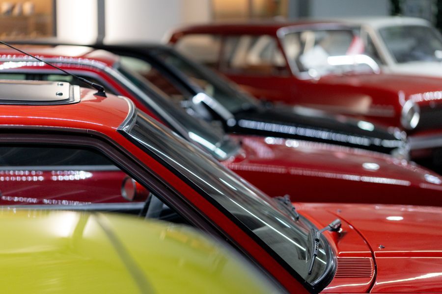 Eine Reihe roter Autos ist in einer Garage geparkt.