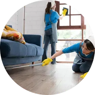 Dos mujeres están limpiando el suelo de una sala de estar.