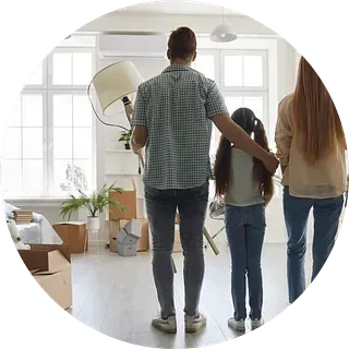 Una familia está de pie en una sala de estar mirando su nuevo hogar.