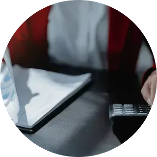 Una persona está sentada en una mesa usando una tableta y un control remoto.