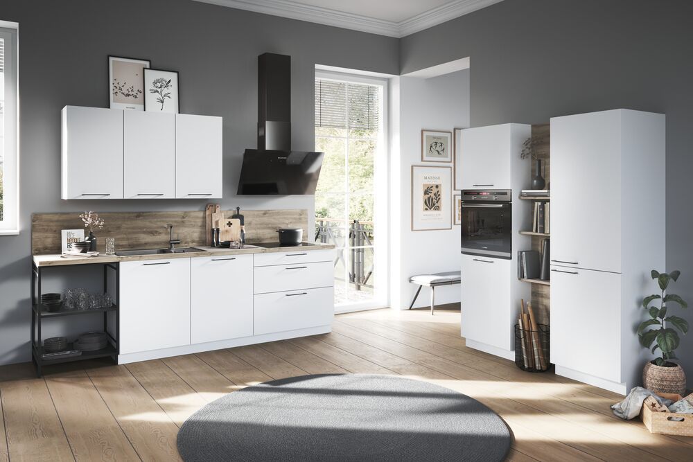 Eine Küche mit weißen Schränken in zwei Zeilen in einem offenen Wohnraum mit Holzboden