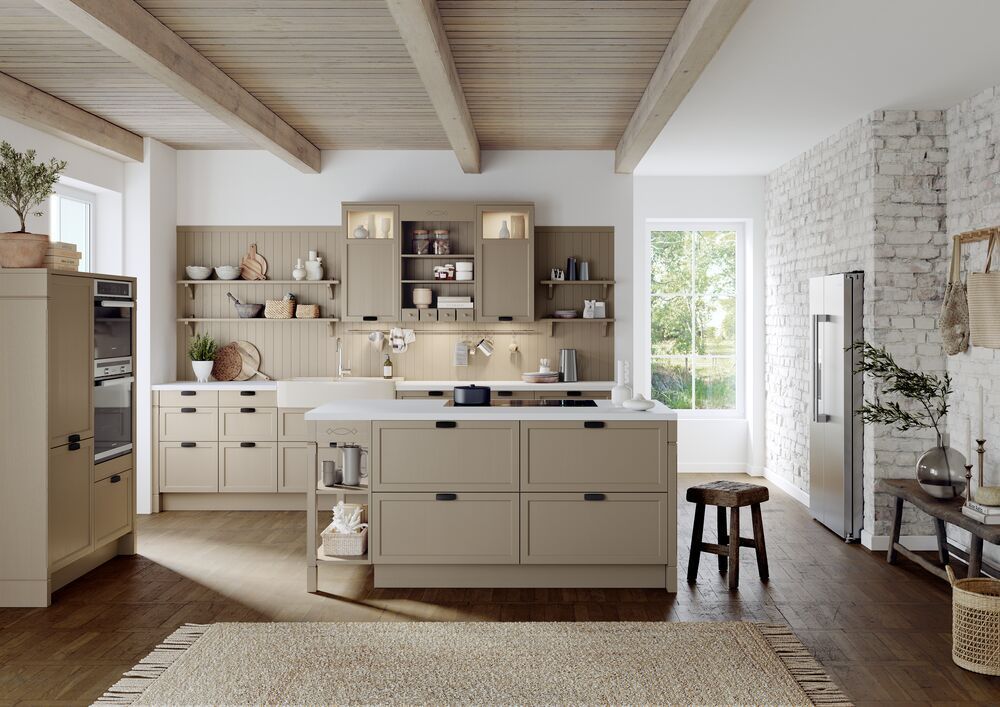 Eine beige Landhausküche mit einer großen Insel in der Mitte des Raumes.