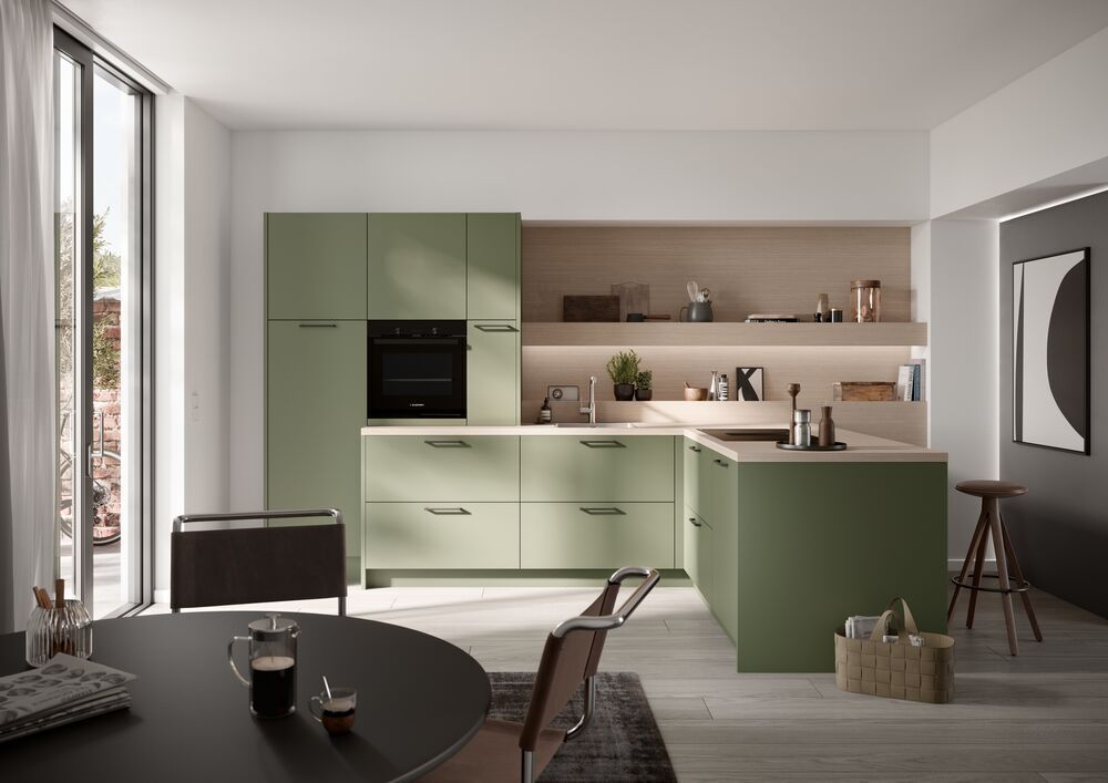 Eine Küche mit grünen Fronten und Holzakzenten.