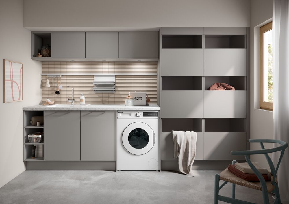 Eine dunkelgraue Waschküche mit Waschmaschine, Spüle und Wäscheregalen.