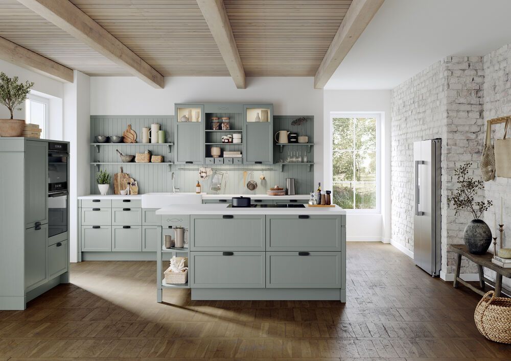 Eine große Landhausküche in Eukalyptus mit einer breiten Insel in der Mitte des Raumes.