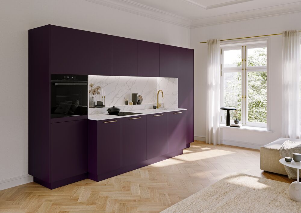 Eine kleine elegante Küche mit matten violetten Fronten in einem offenen Wohnzimmer.