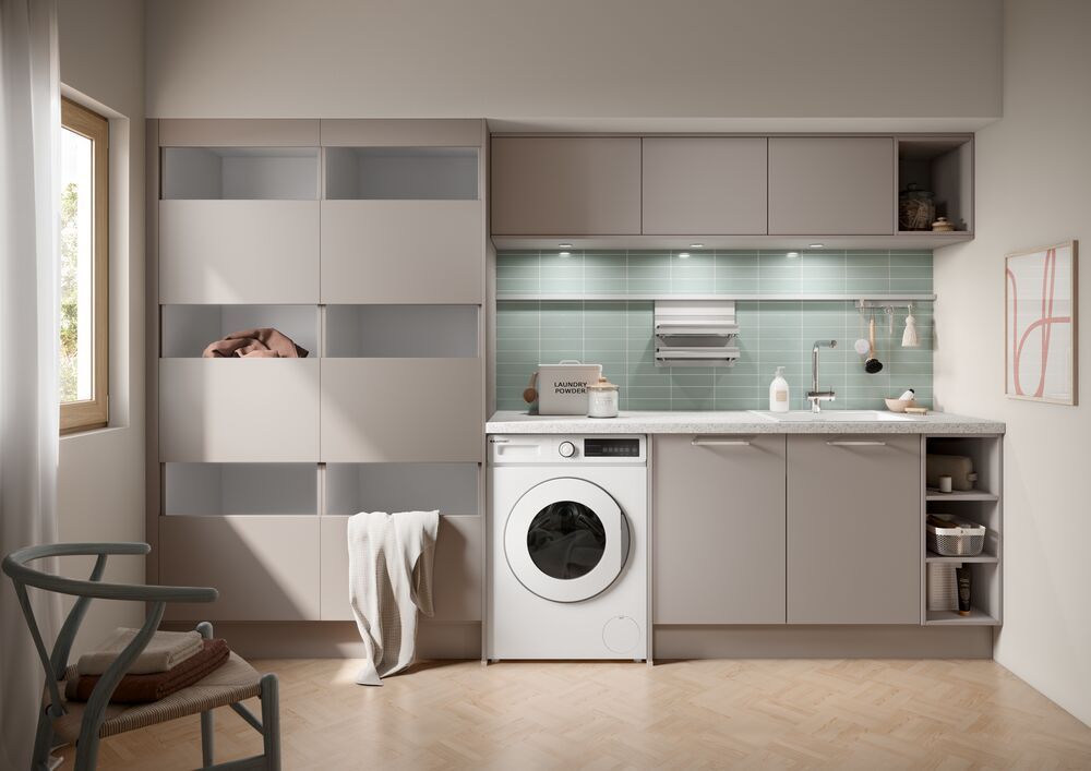 Eine graue Waschküche mit Waschmaschine, Spüle und Wäscheregalen.