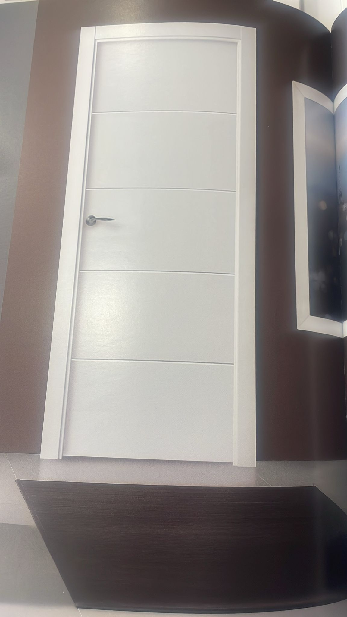 Una puerta blanca con un cuadro en la pared detrás de ella.
