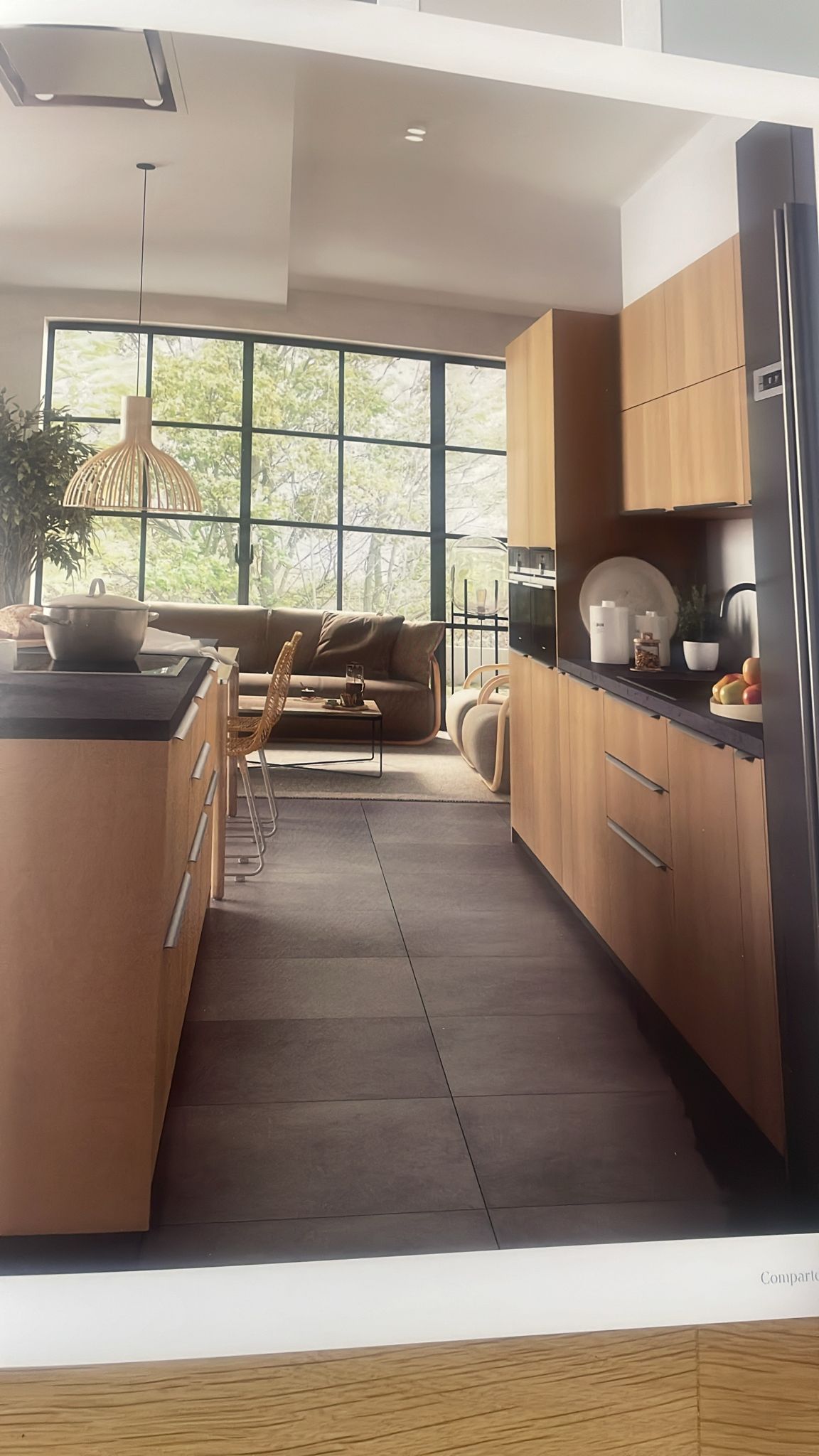 Una cocina con gabinetes de madera y un refrigerador negro.