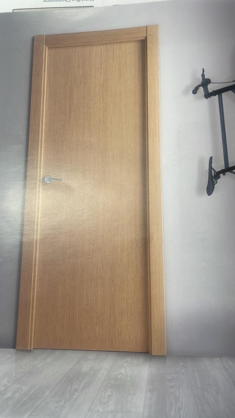 Una puerta de madera está en una habitación al lado de una pared.