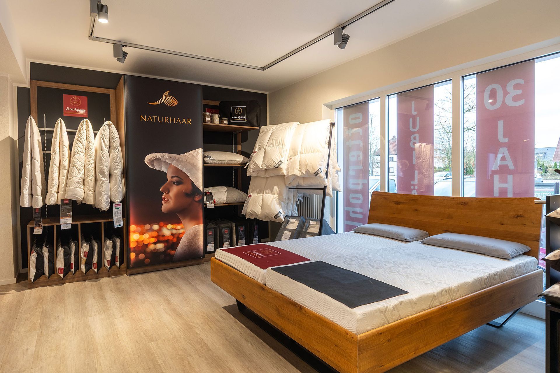Innenansicht eines Schlafzimmermöbelgeschäfts mit Bett, Bettwäsche und Ausstellungsstücken.
