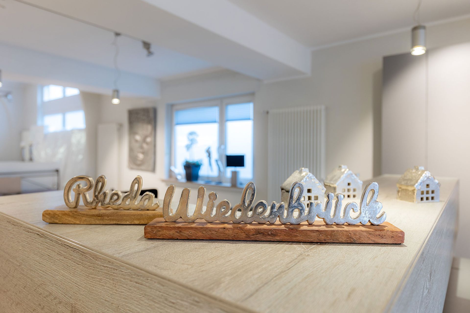 Im Inneren befindet sich ein Holzschild mit der Aufschrift „Rheda-Wiedenbrück“ auf einer hellen Theke.