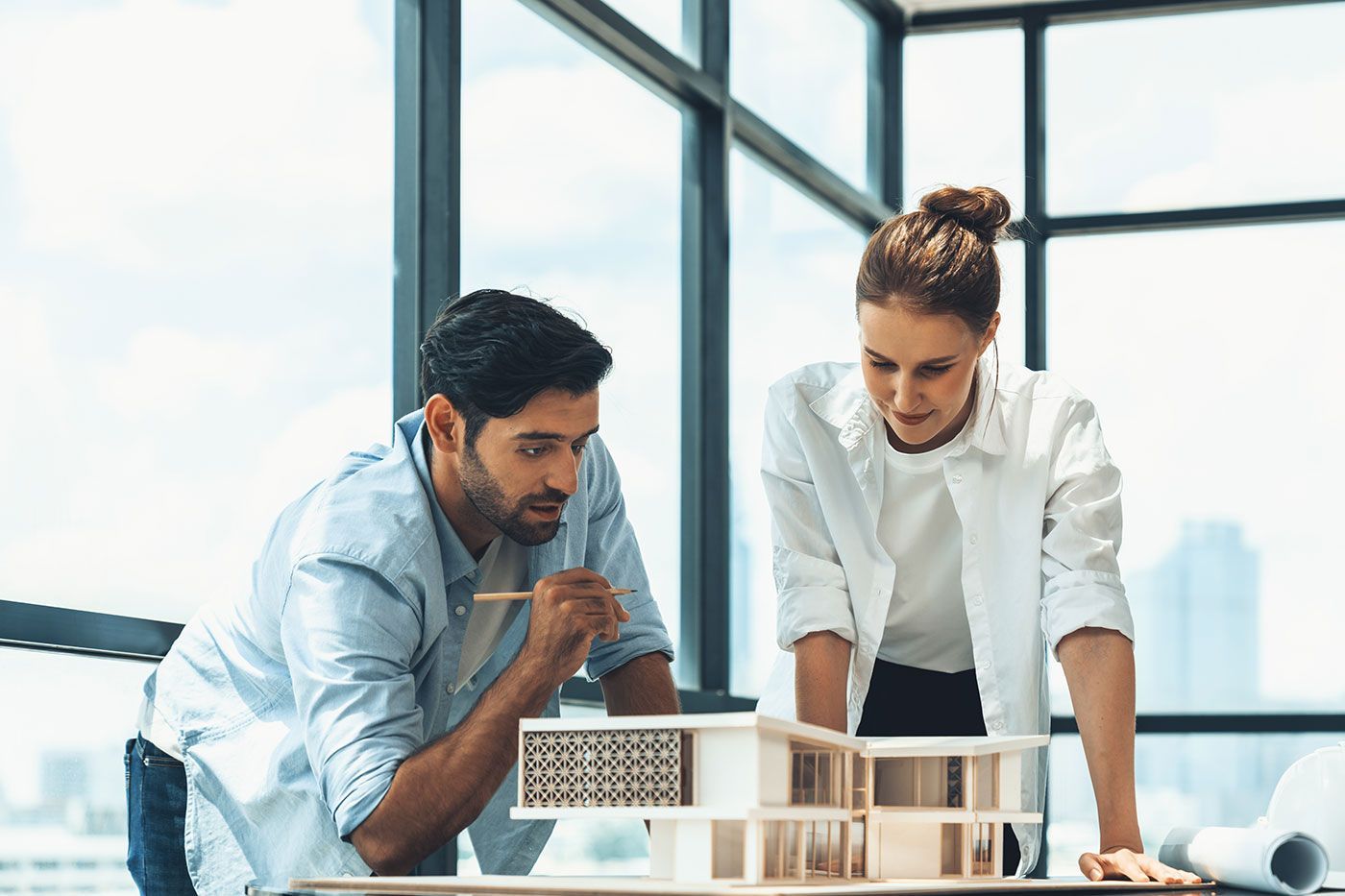 Deux personnes qui discutent devant une maquette de maison