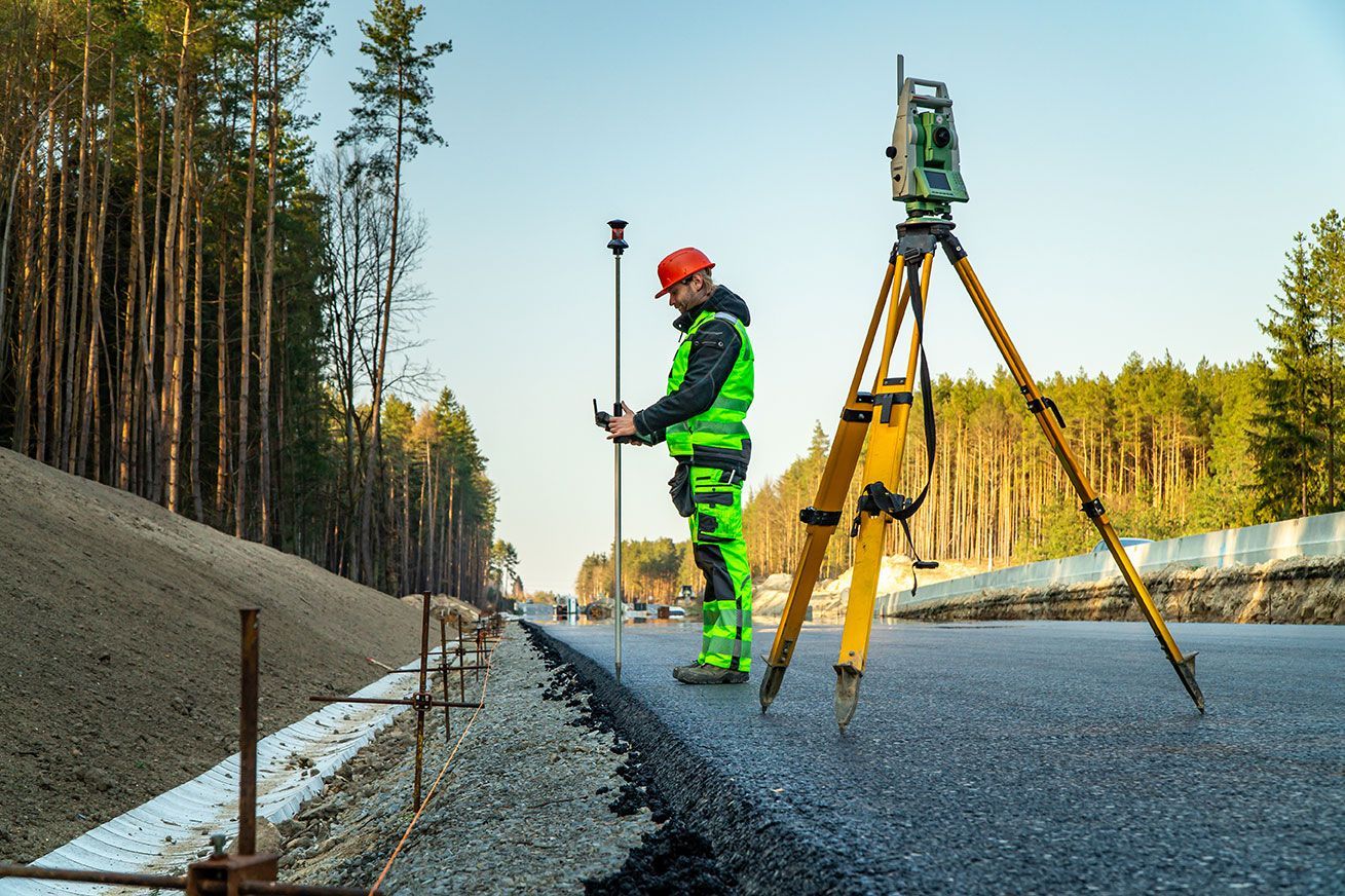 Géomètre qui prend des mesures sur la route