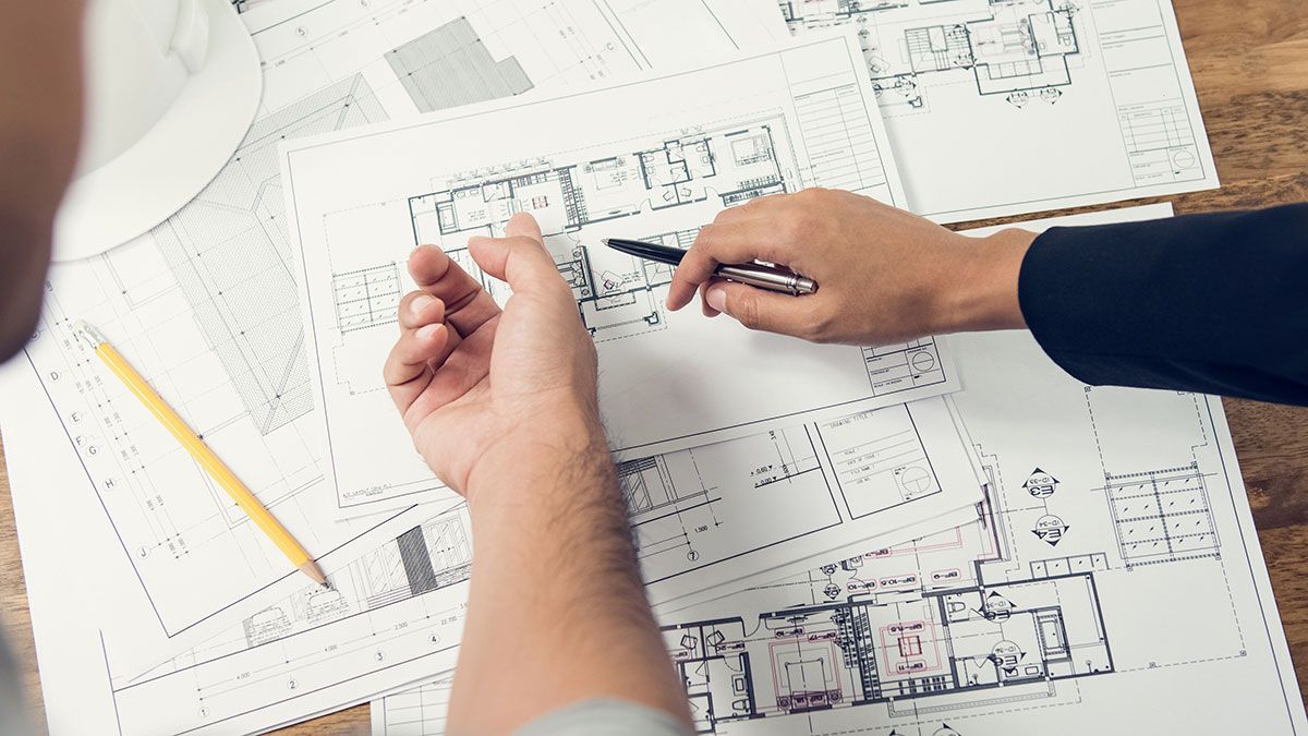 Ingénieur et architecte qui discutent autour d'un plan de maison