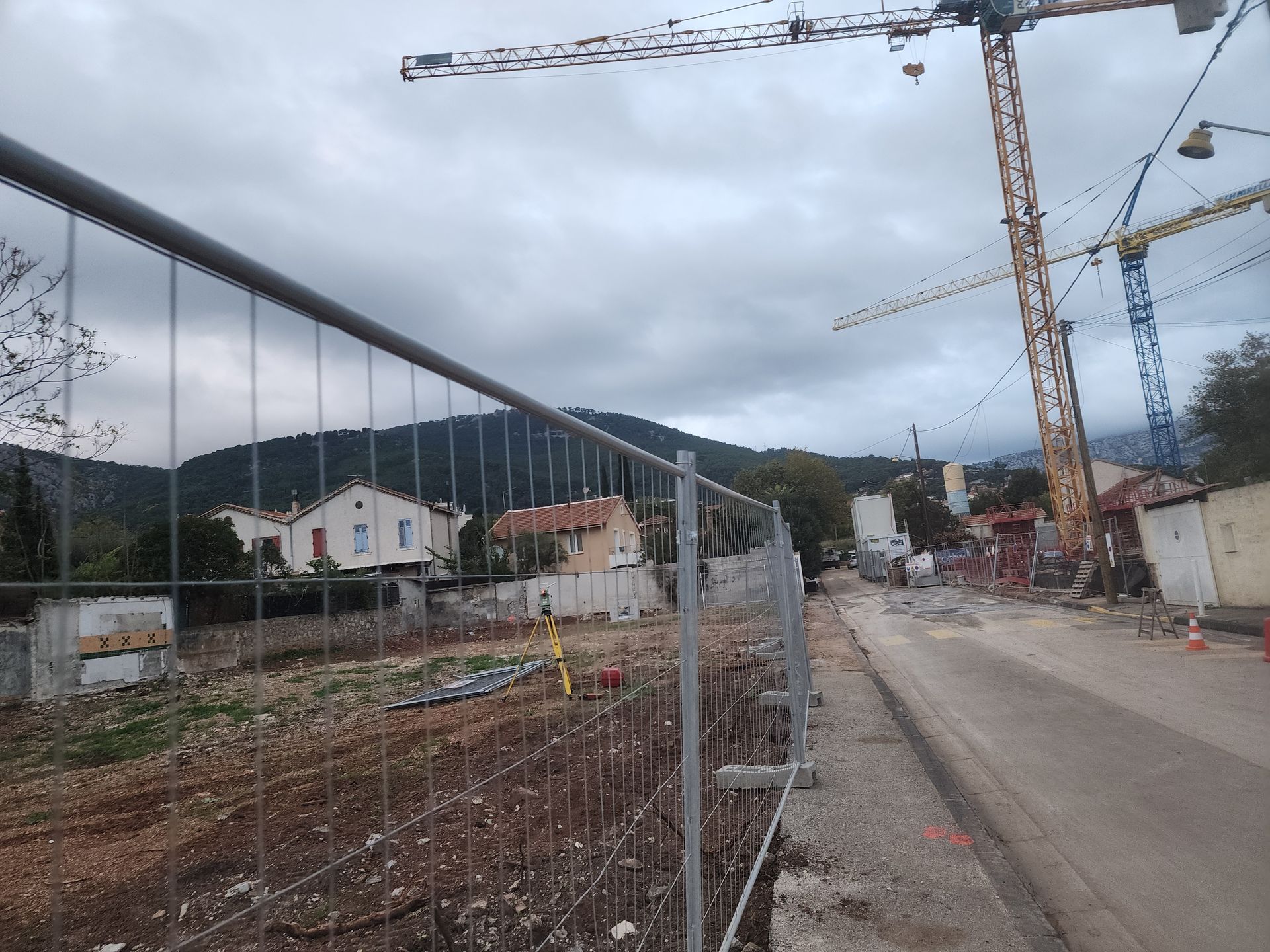 Géomètre effectuant un relevé de terrain à Trets, avec vue sur les vignes et la Sainte-Victoire