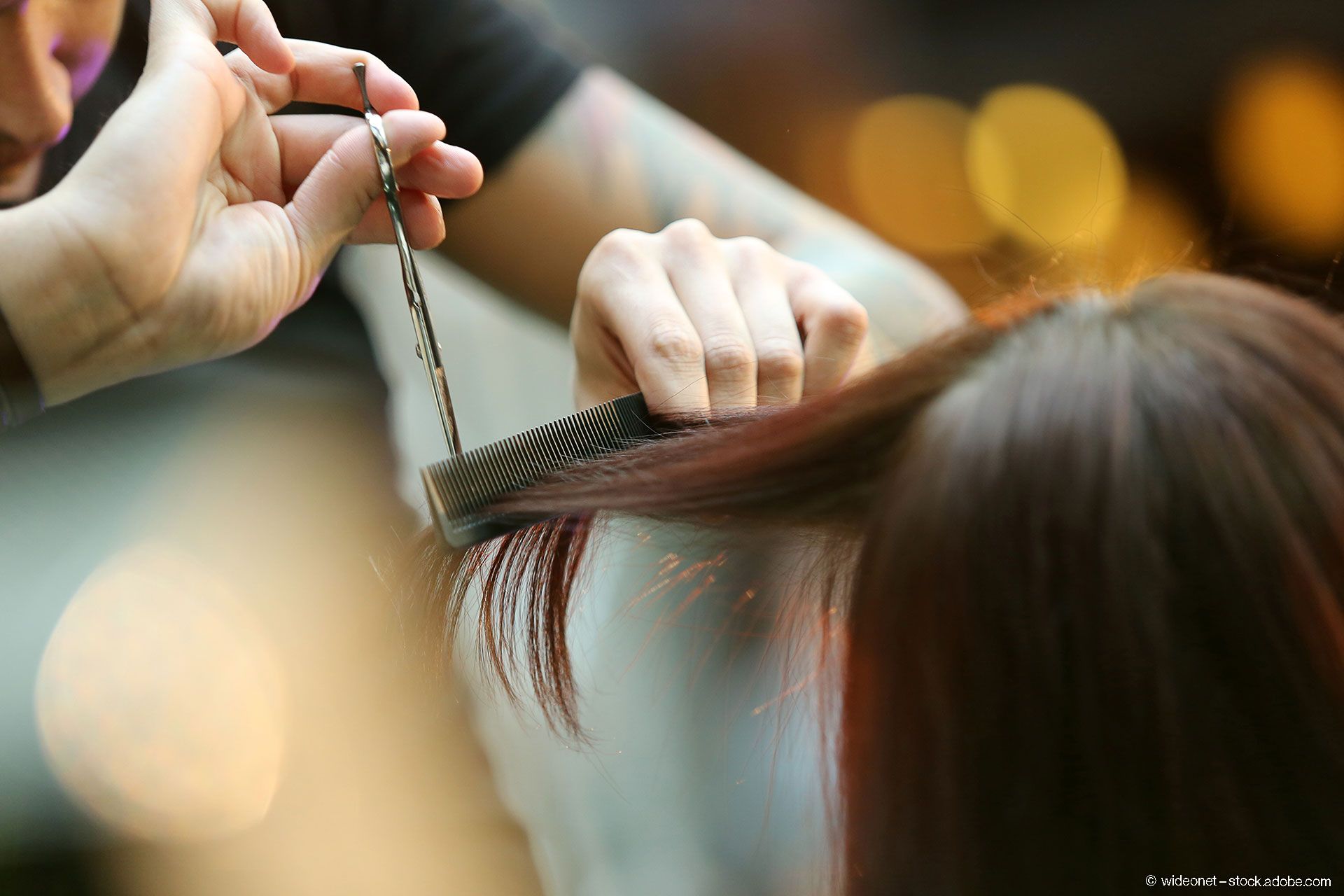 Friseurin schneidet Haare von einer Dame
