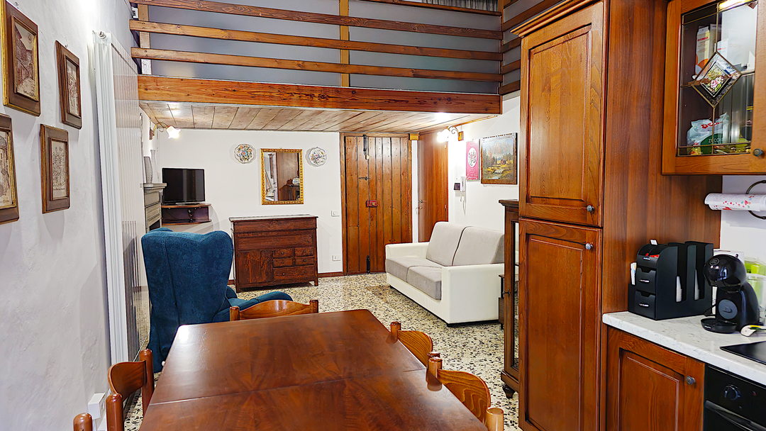 Sala da pranzo con tavolo e cucina in legno dell'appartamento