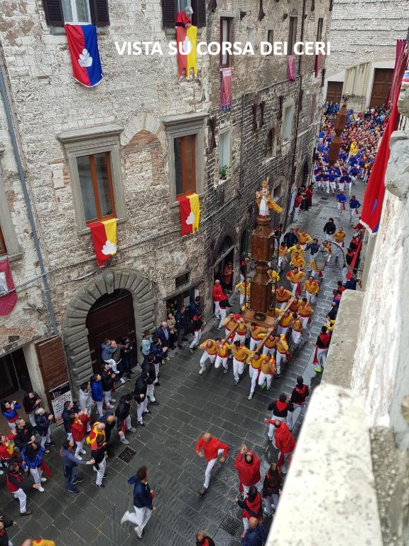 Finestra con bandiere e vista panoramica sulla Corsa dei Ceri a Gubbio