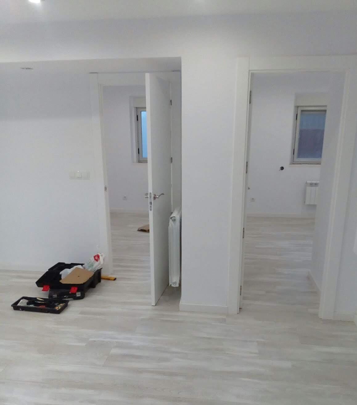Hay una maleta en el suelo en el medio de la habitación.