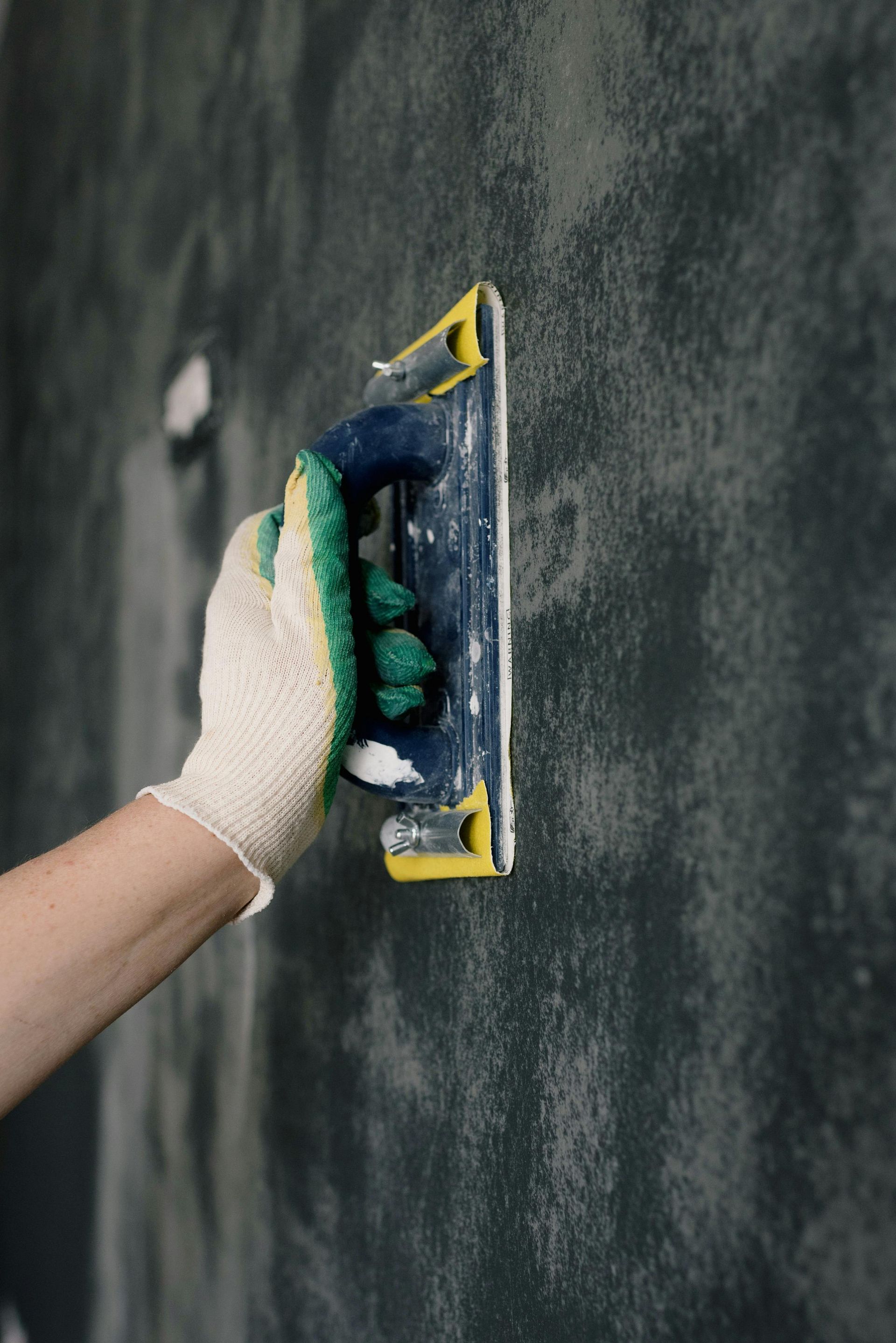 Una persona está enyesando una pared con una paleta.