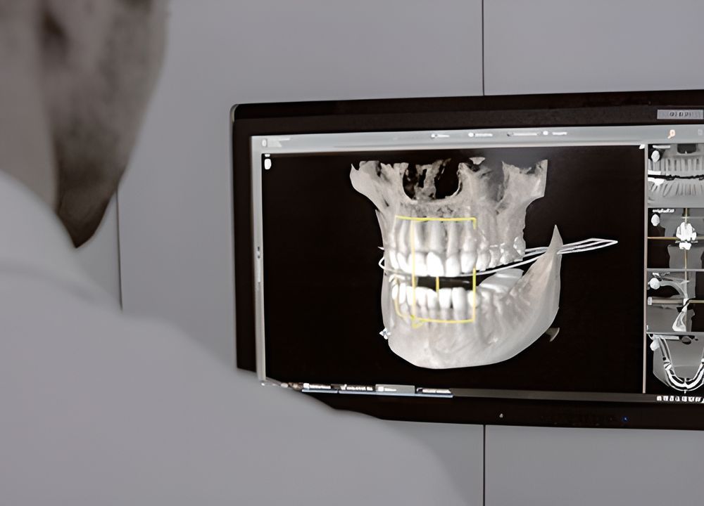 Ein Mann schaut auf einen Computerbildschirm, auf dem ein Totenkopf und Zähne zu sehen sind