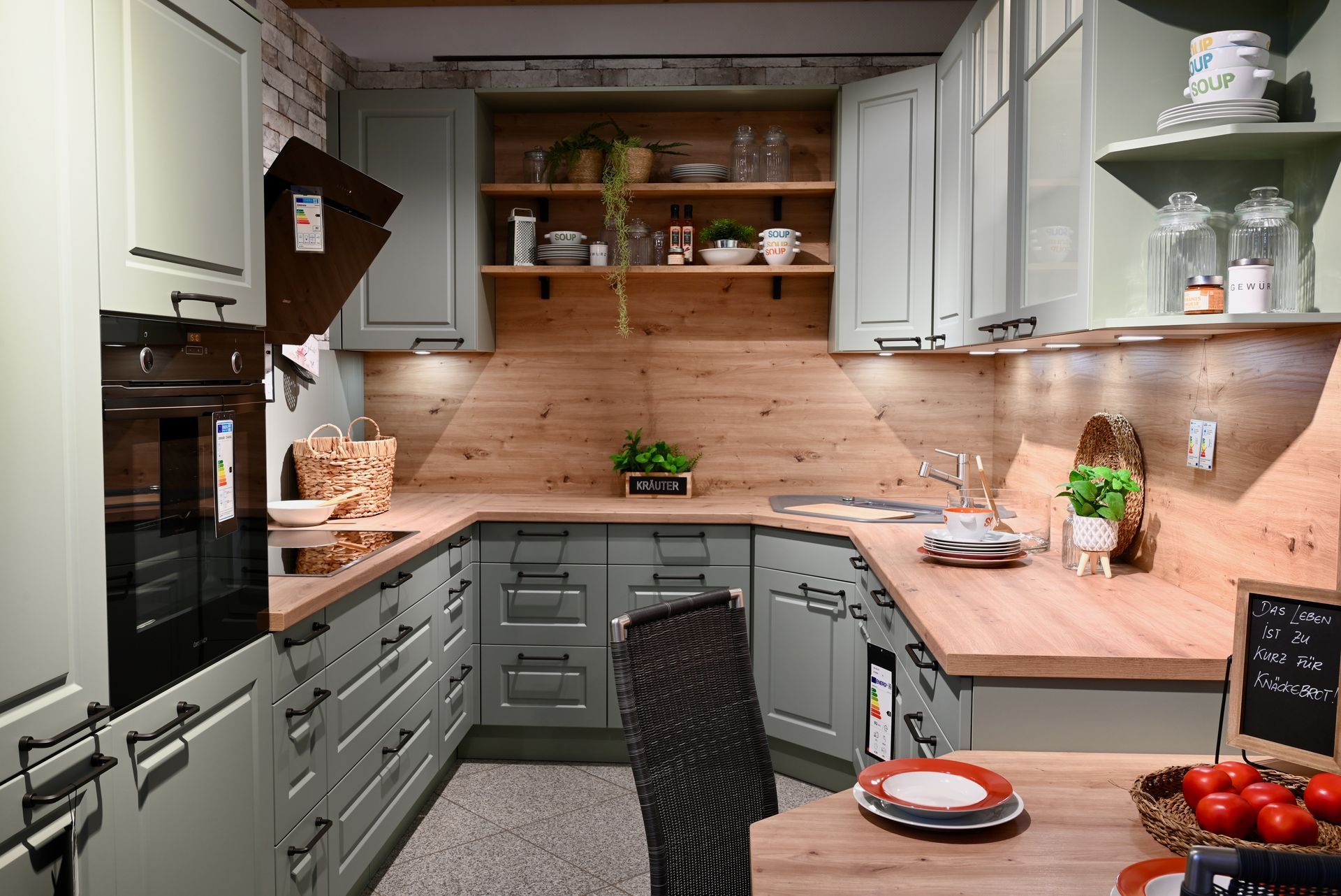 Eine Küche mit grauen Schränken und Holzarbeitsplatten.