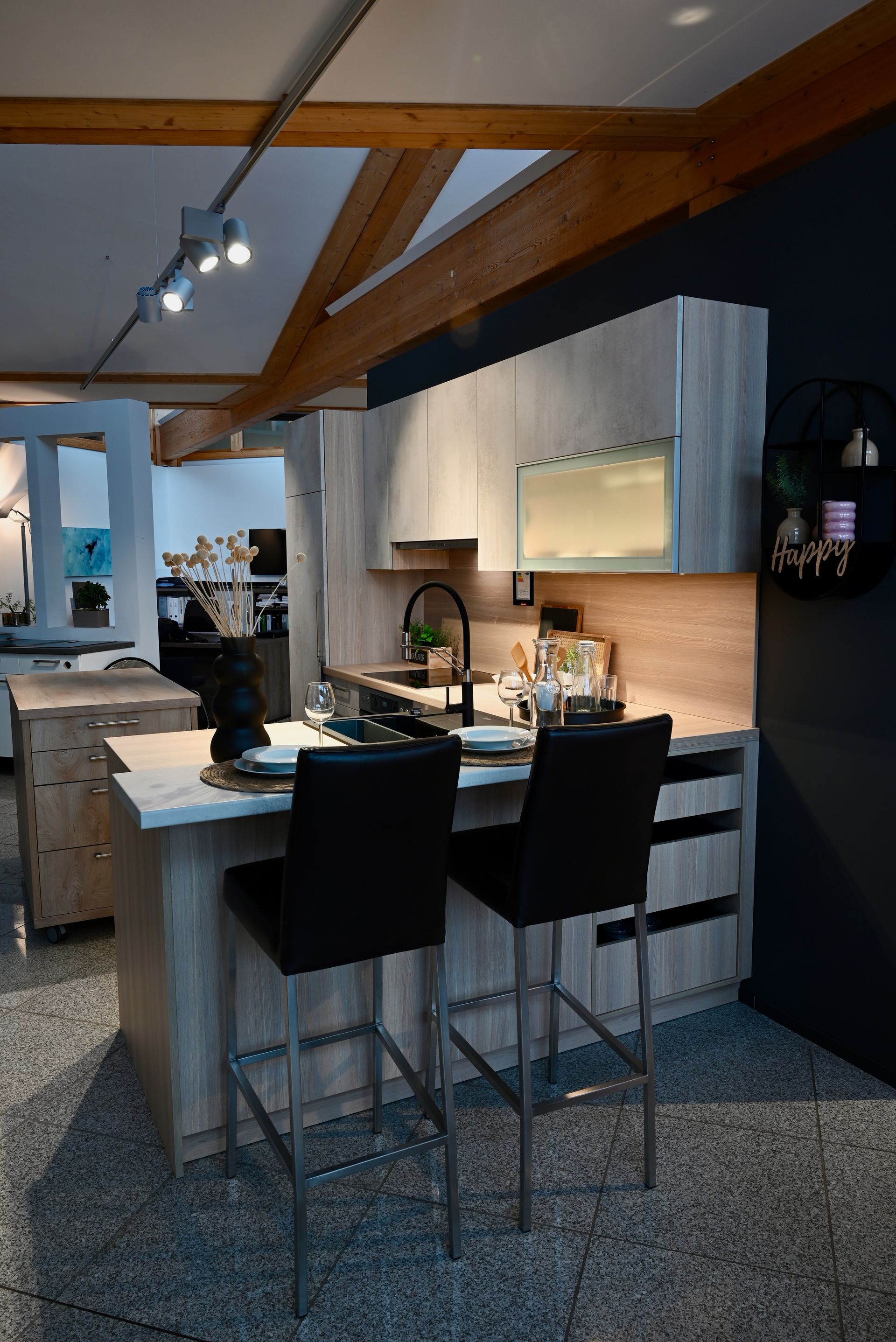 Eine Küche mit Bar und Stühlen in einem Ausstellungsraum.