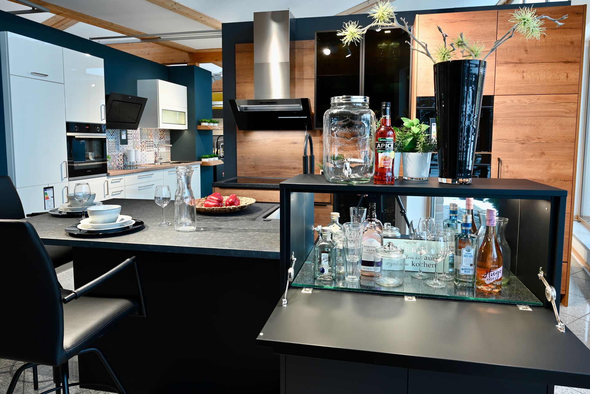 Eine Küche mit Tisch und Stühlen und einer Bar mit Flaschen darauf.