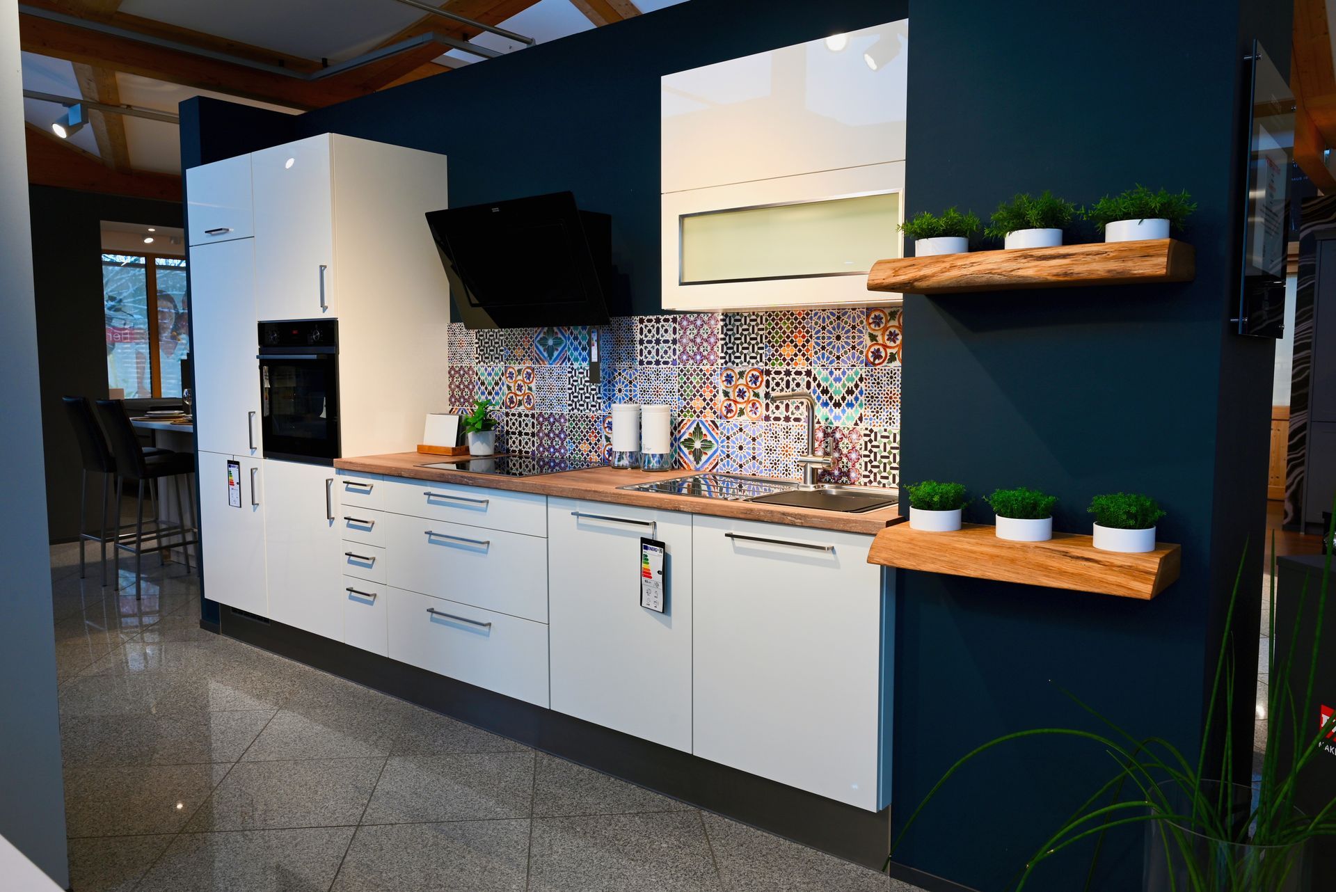 Eine Küche mit weißen Schränken und einer blauen Wand