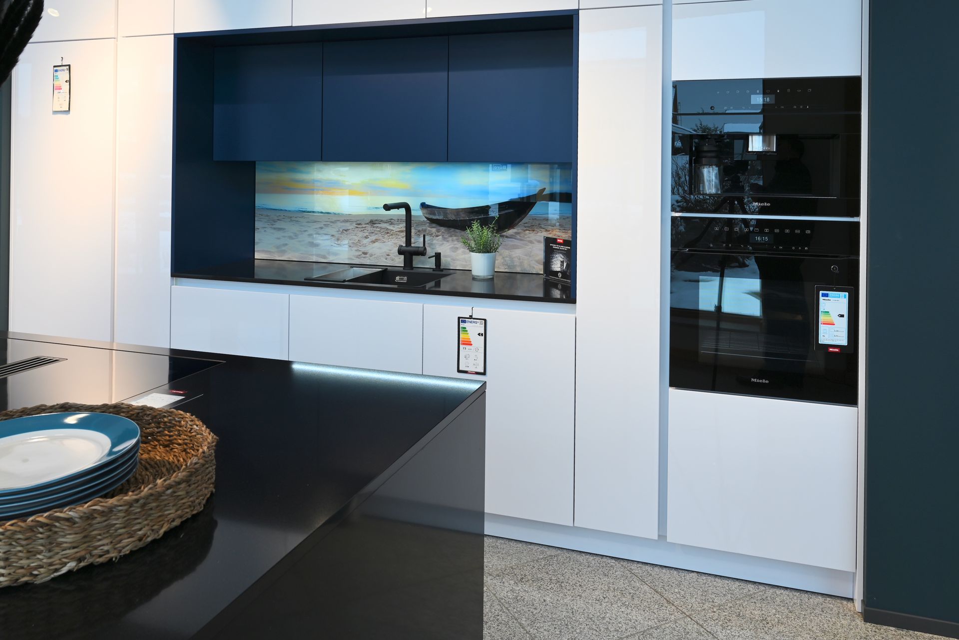 Eine Küche mit weißen Schränken und einer schwarzen Arbeitsplatte.