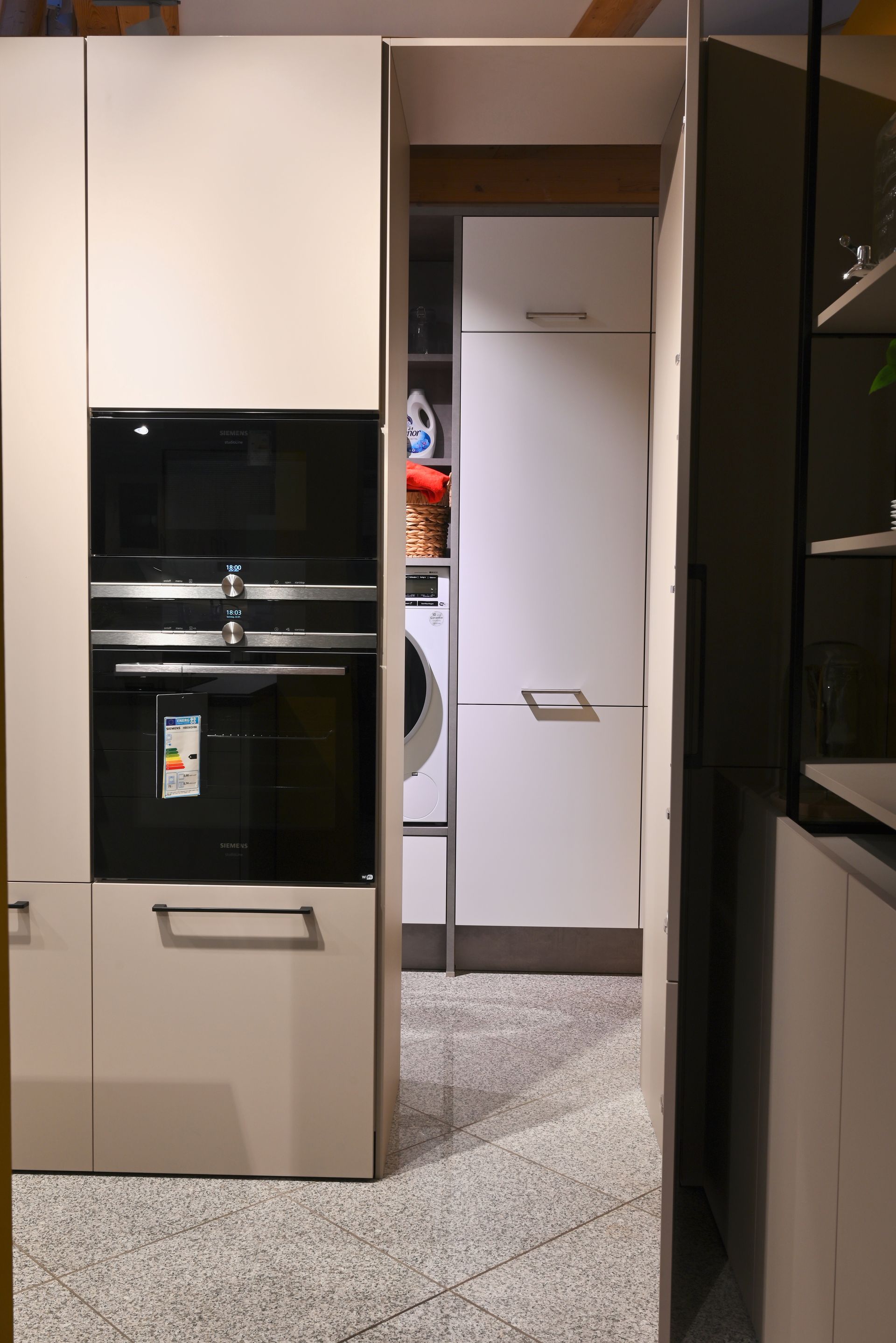 Eine Küche mit Waschmaschine, Trockner und Mikrowelle.