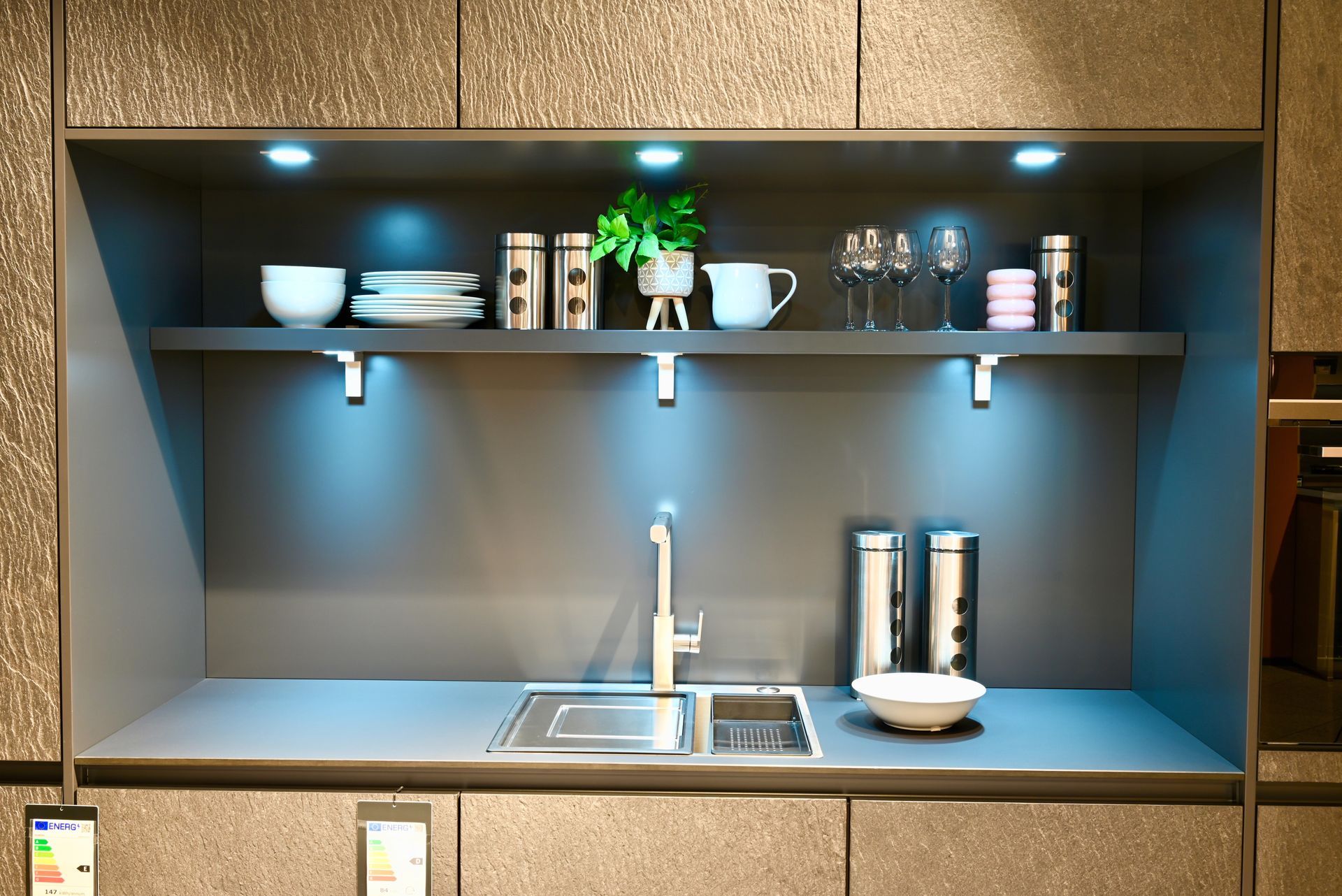 Eine Küche mit einer Spüle und einem Regal mit Geschirr darauf