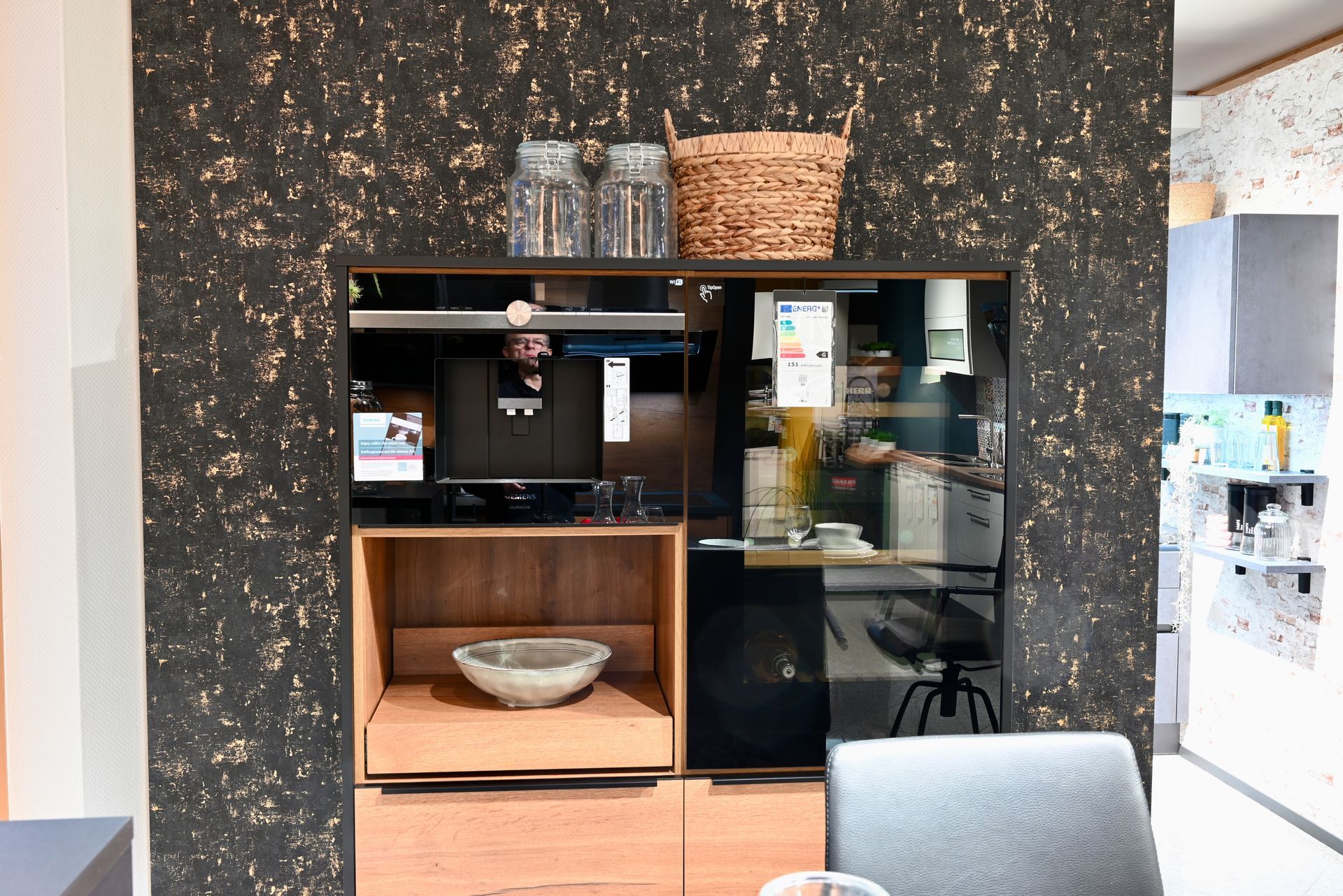 Eine Küche mit einem schwarzen Kühlschrank und einem Holzschrank