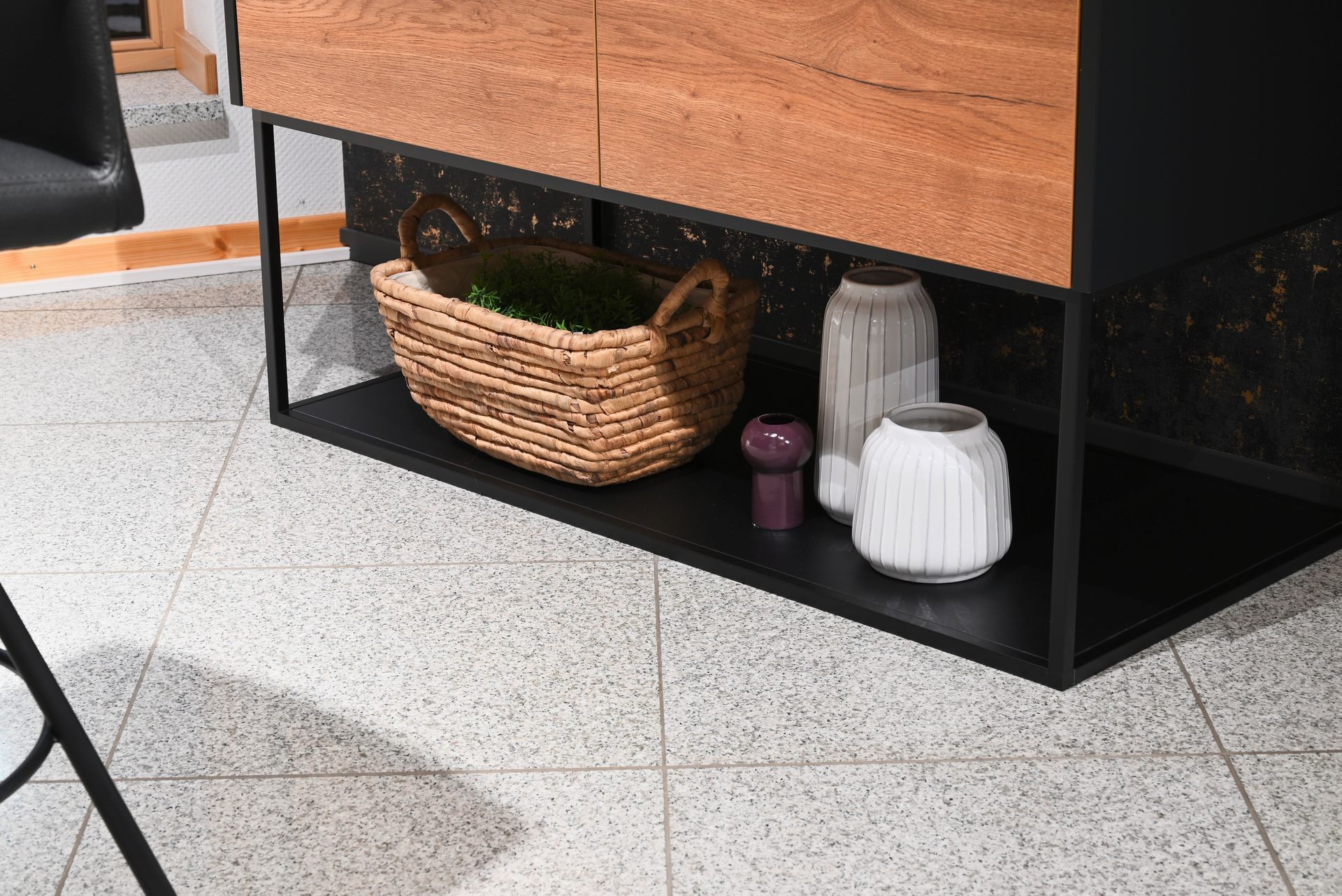 Ein Weidenkorb steht auf einem Regal unter einem Holzschrank.