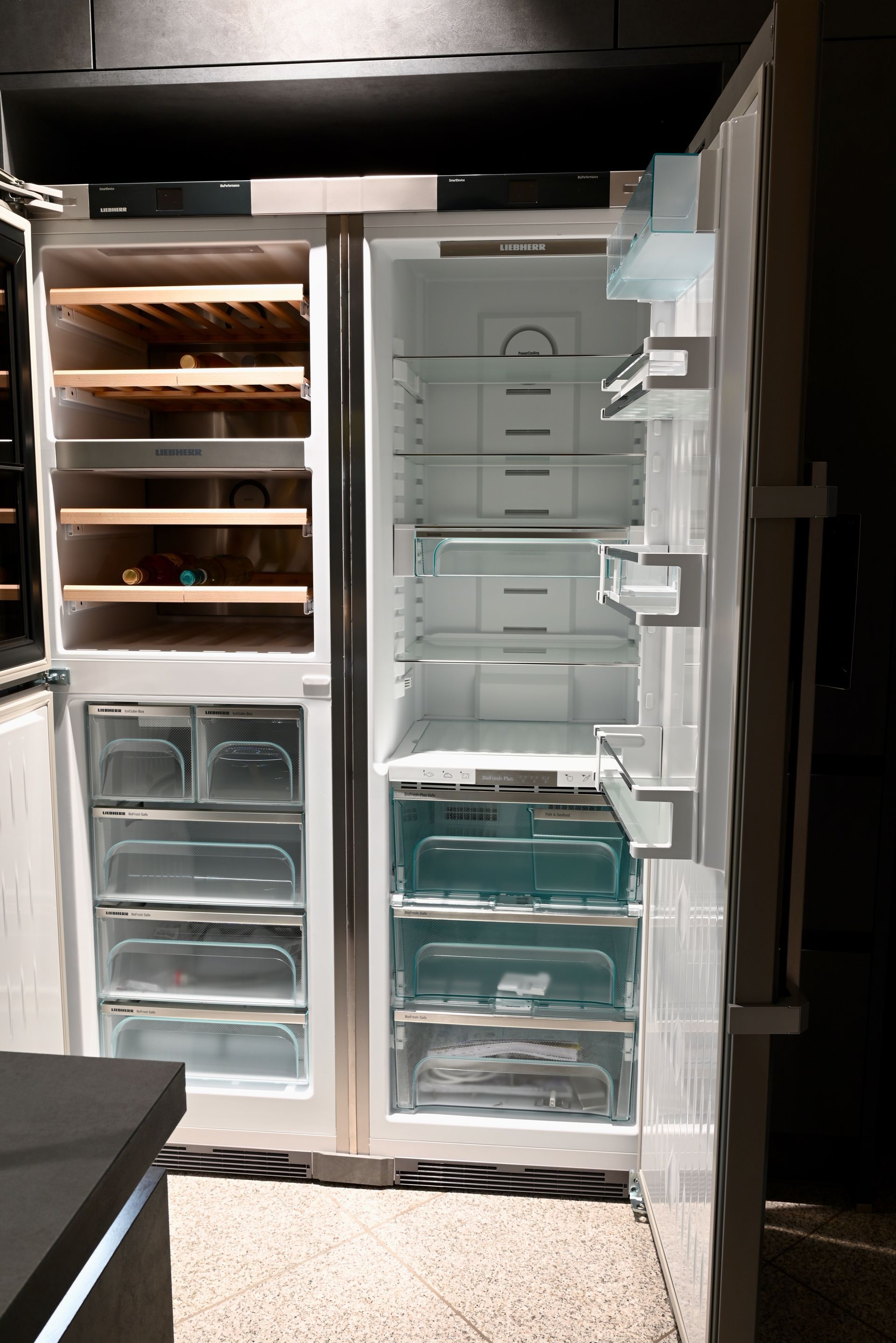 Ein leerer Kühlschrank mit offener Tür in einer Küche.