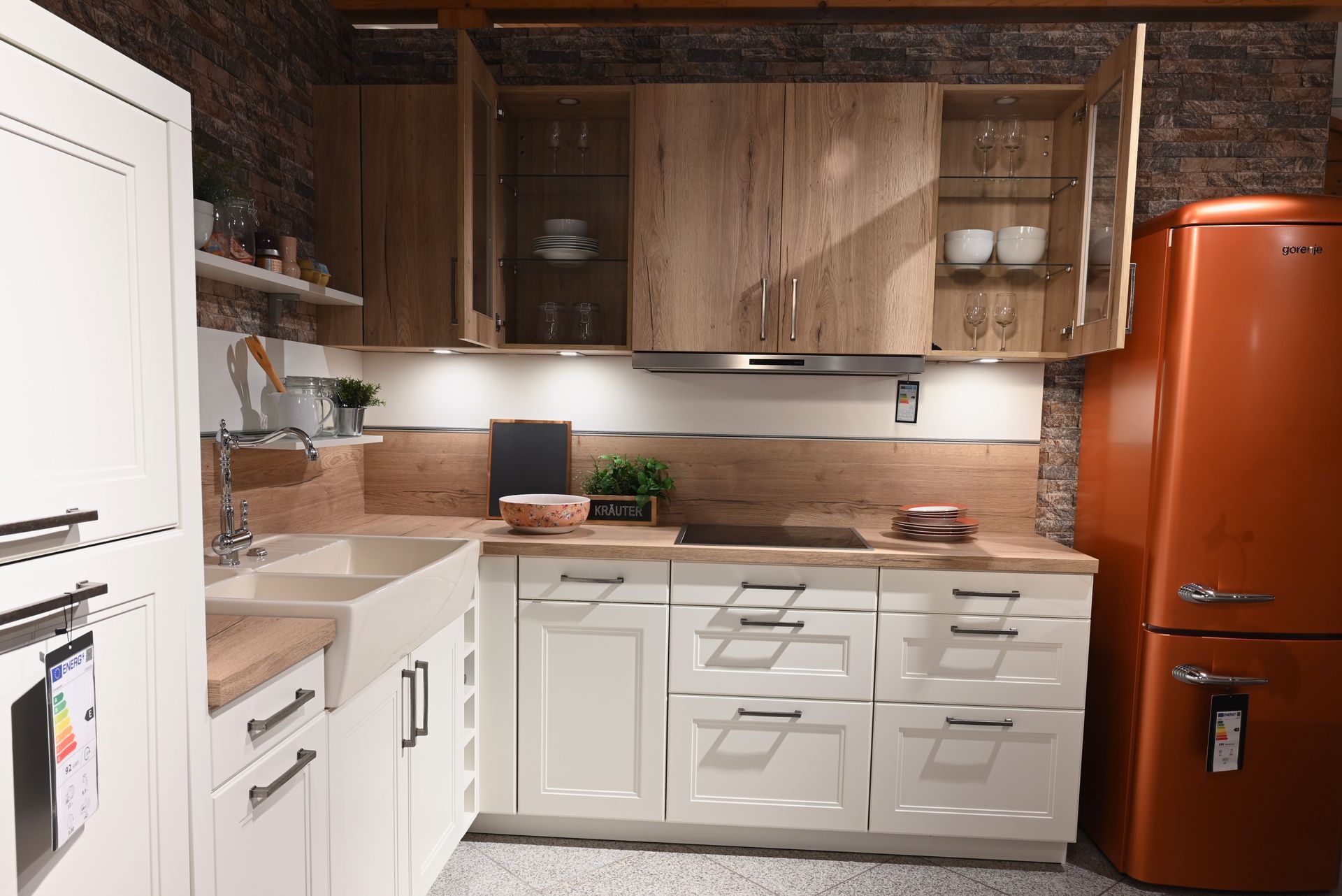 Eine Küche mit weißen Schränken und einem orangefarbenen Kühlschrank