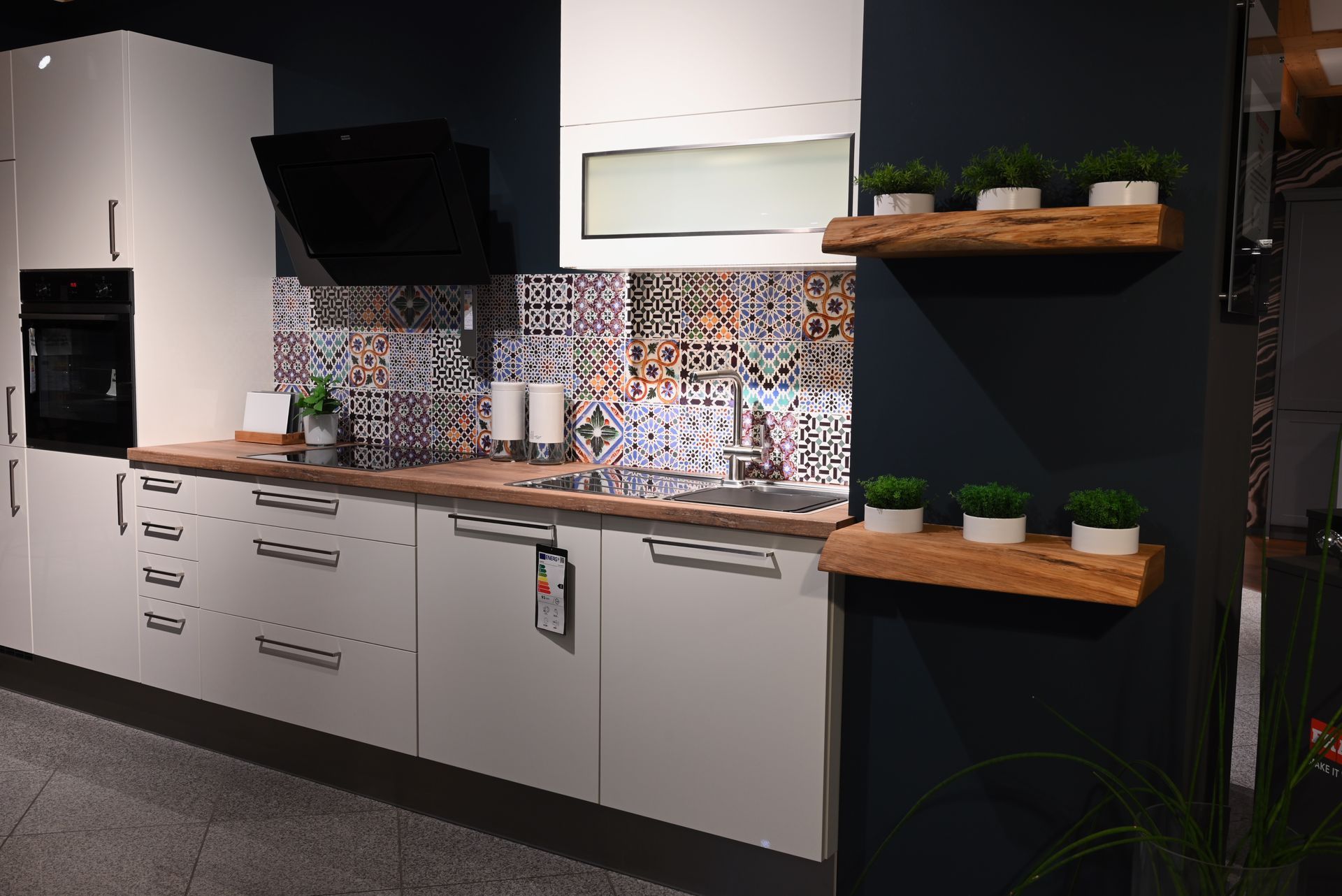 Eine Küche mit weißen Schränken, einer Spüle und einem Herd.