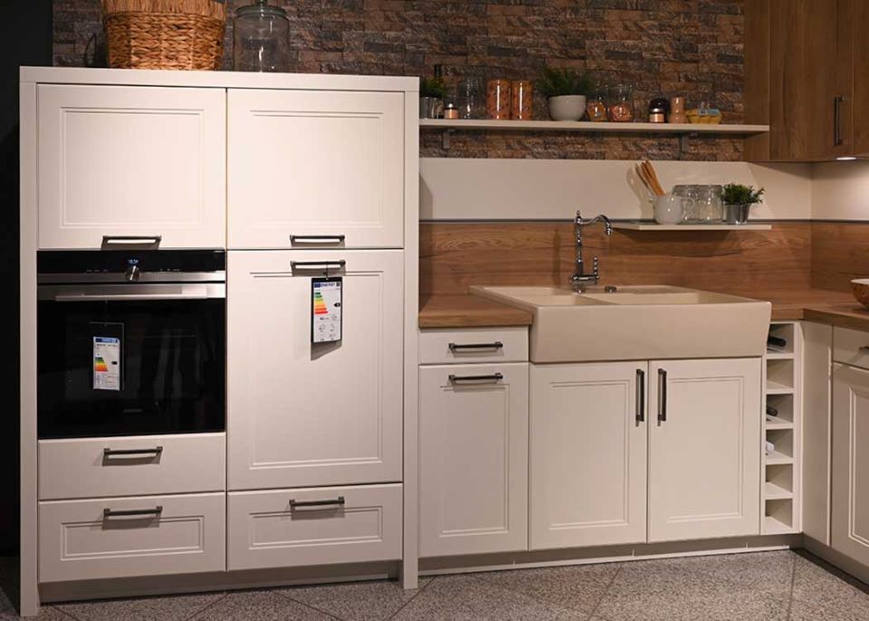 Eine Küche mit weißen Schränken und einem schwarzen Ofen