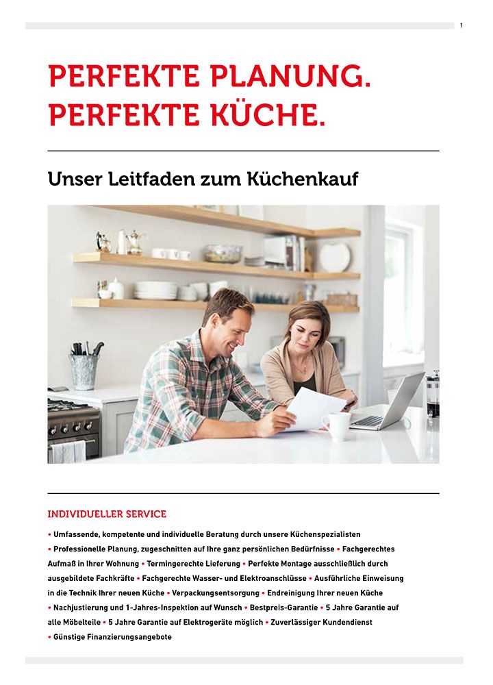 Ein Mann und eine Frau sitzen an einem Tisch in einer Küche und schauen auf einen Laptop.