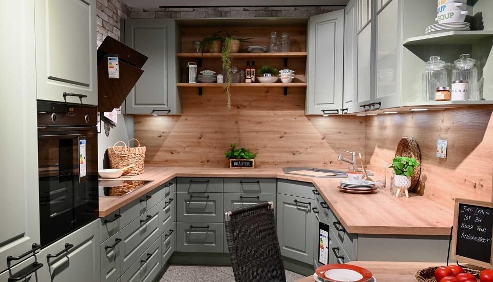 Eine Küche mit grauen Schränken und Holzarbeitsplatten.