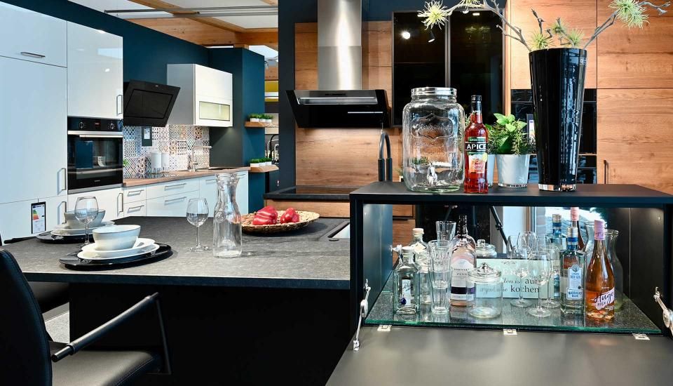 Eine Küche mit Tisch und Stühlen und einem Glasregal.